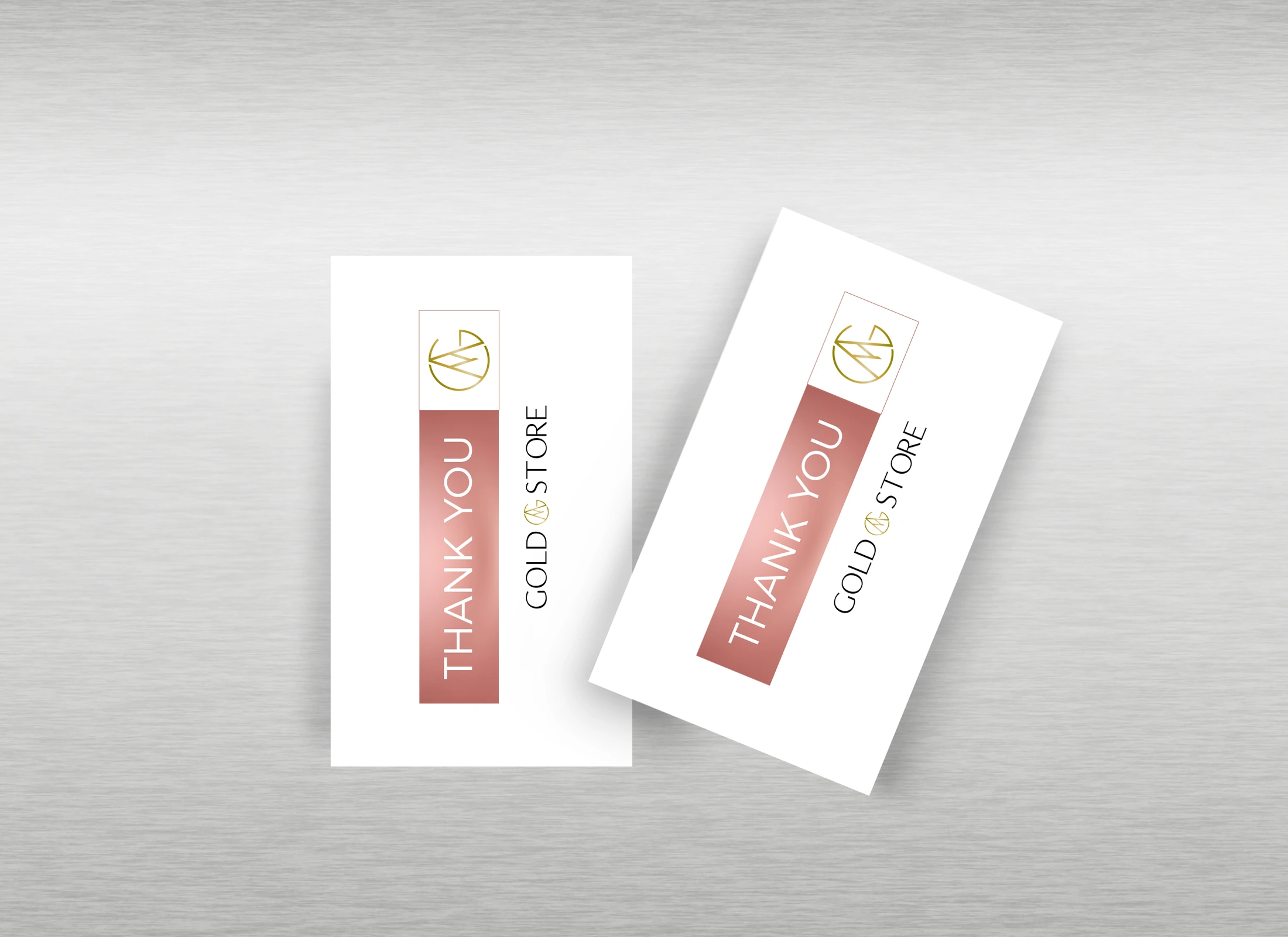 Mockup of two Gold Store thank-you cards on a gray surface, with a gold logo and a pink strip.