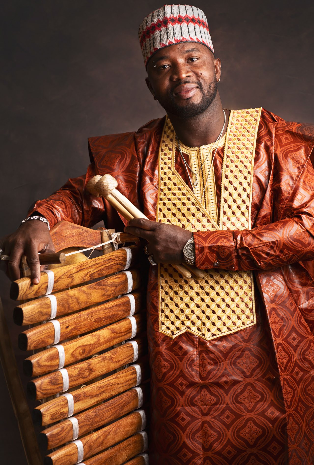 Retrato de Yadi Camara con baquetas y balafón.